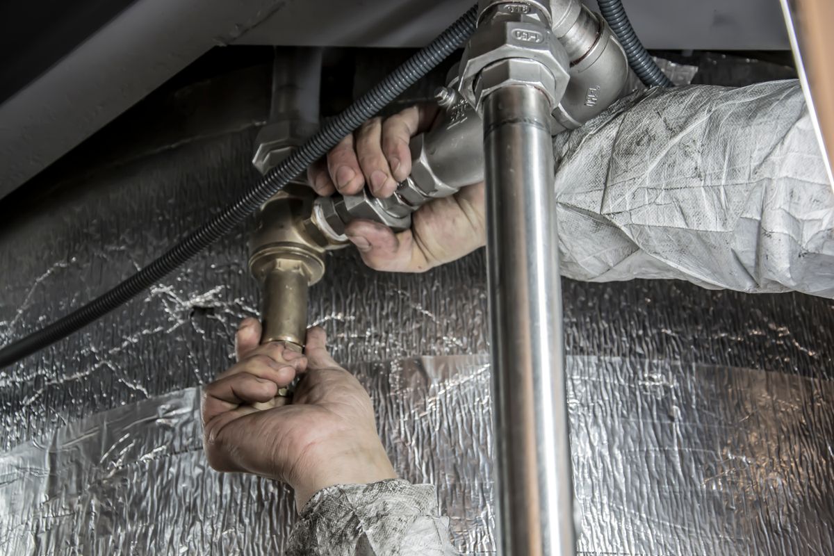 Master Plumber clearing a kitchen drain in Austin Texas