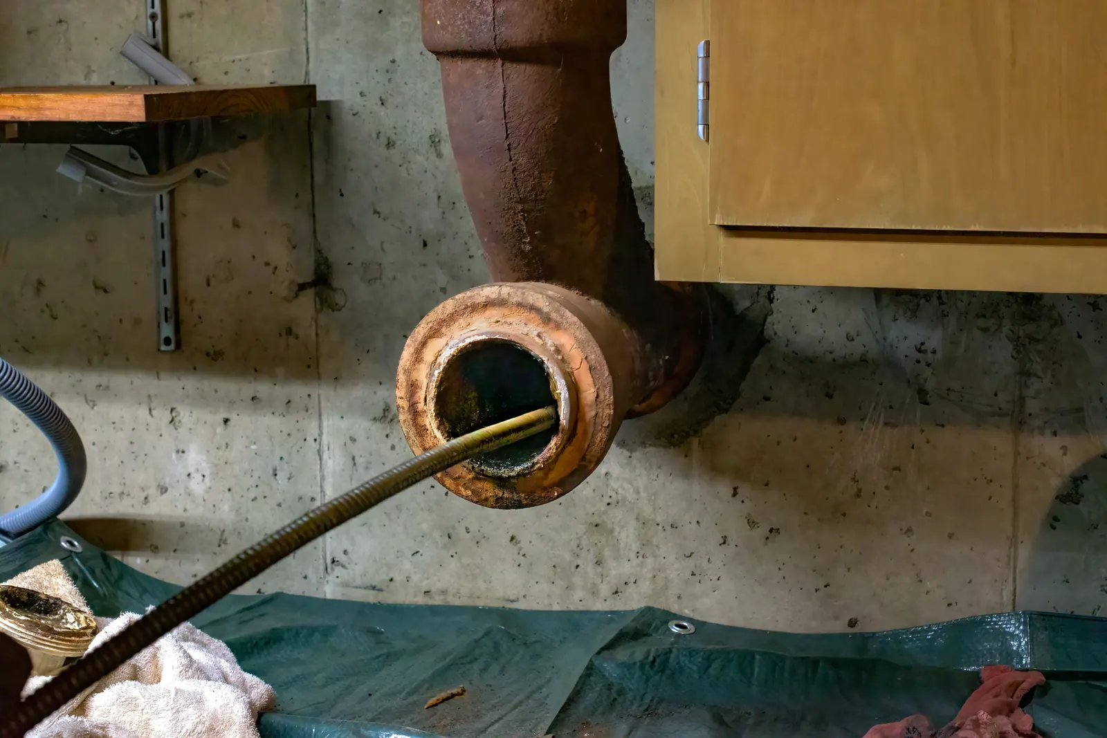 Plumber running a camera scope and drain machine through a main line, the diagnosis-first approach for Elgin's historic laterals