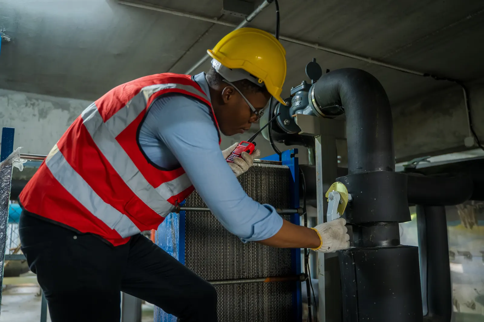 Technician inspecting a water line and valve for leaks, the systematic check used on Kyle new-build homes