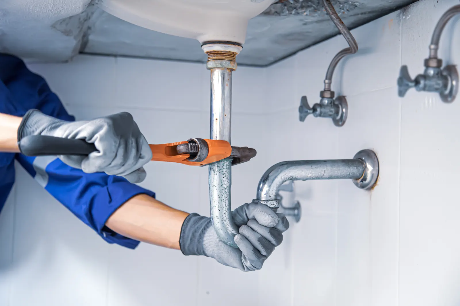 Plumber repairing a water supply line under a sink, the everyday call in Waco's older housing stock