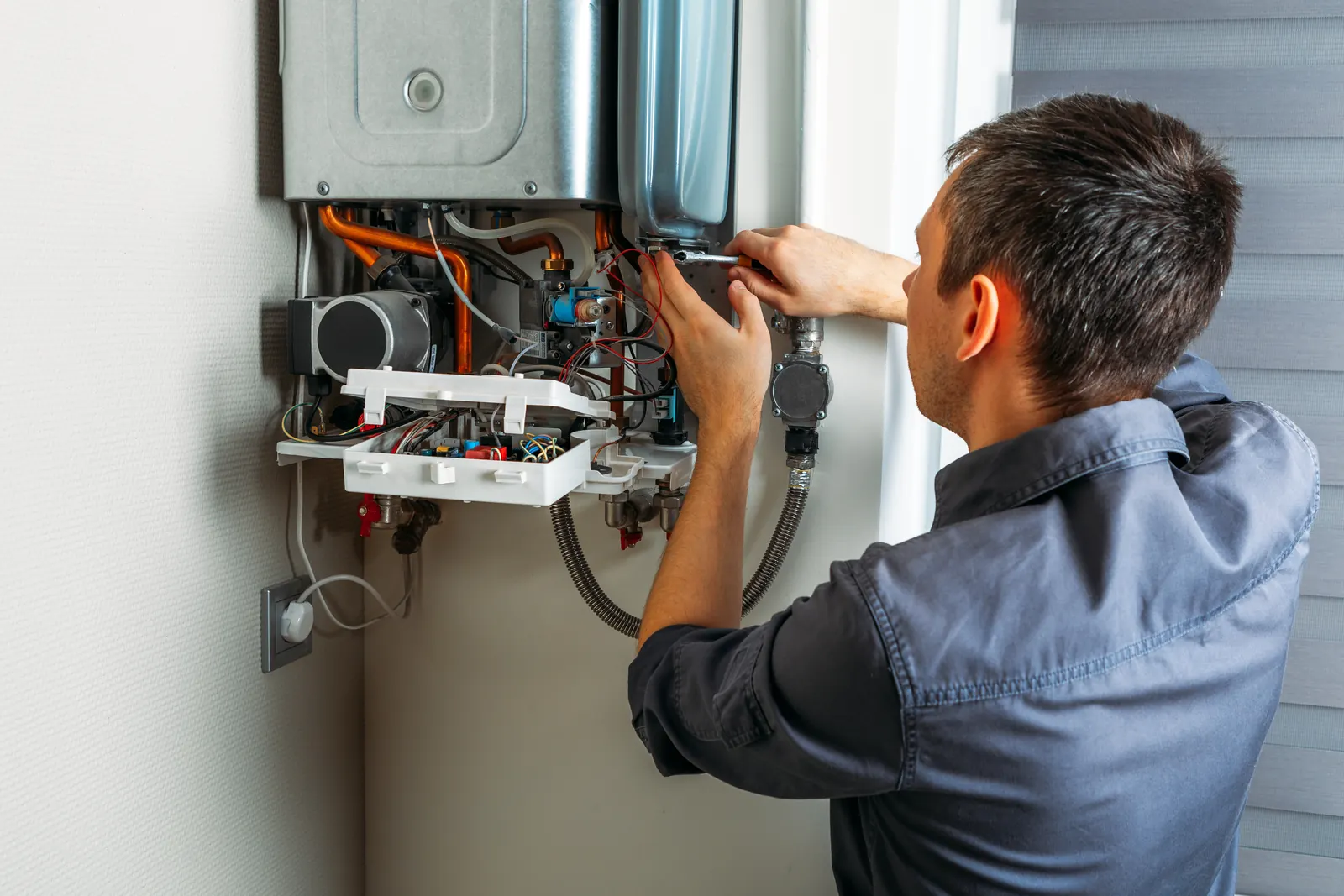 Wall-mounted tankless water heater installation &mdash; the district-standard equipment Mueller, Austin homes run and maintain