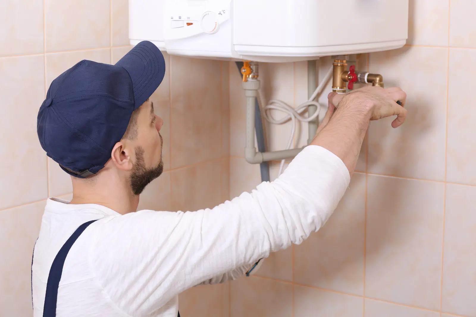 Plumber installing a residential water heater, the most common replacement call in Temple's mid-century housing